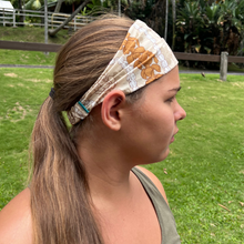 Load image into Gallery viewer, Side view of headwrap showing the Kahele Maui label. Puakenikeni and pikake lei in neutral colors